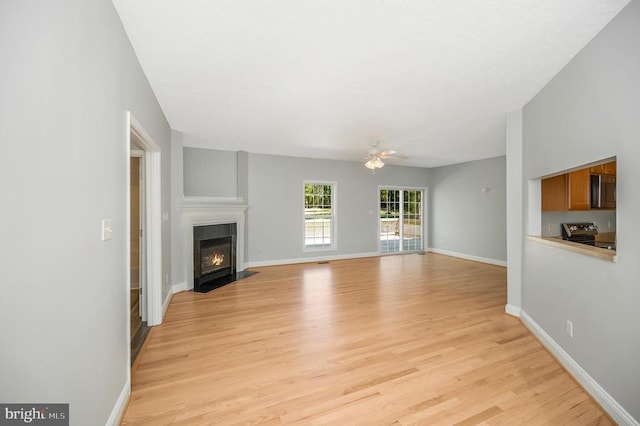 unfurnished living room featuring light hardwood / wood-style floors and ceiling fan