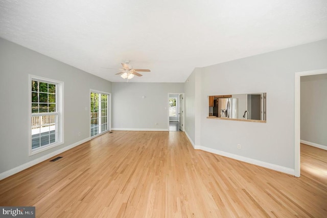 unfurnished living room with ceiling fan and light wood-type flooring