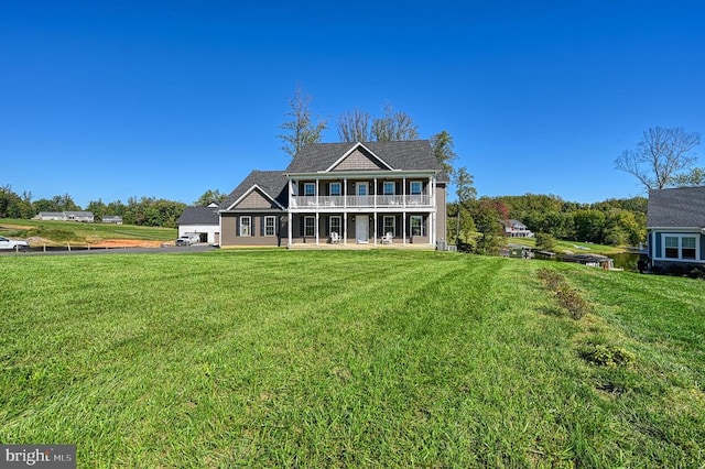 back of house with a balcony and a lawn