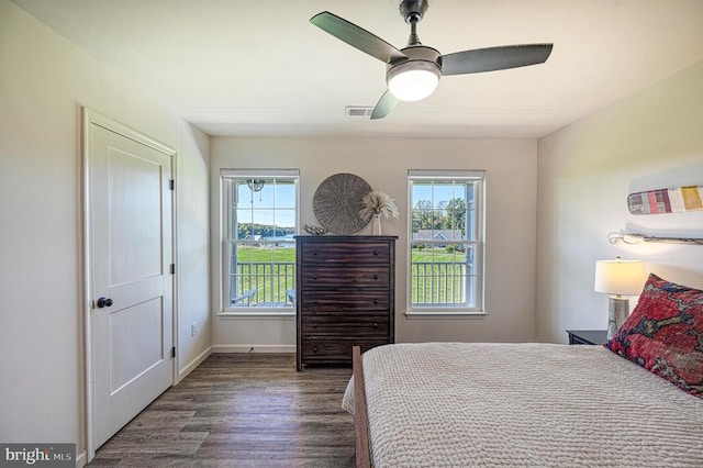 bedroom featuring dark wood-type flooring, multiple windows, and ceiling fan