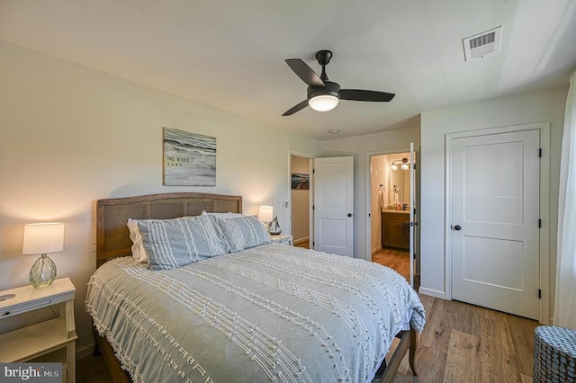 bedroom featuring ceiling fan, connected bathroom, and hardwood / wood-style floors