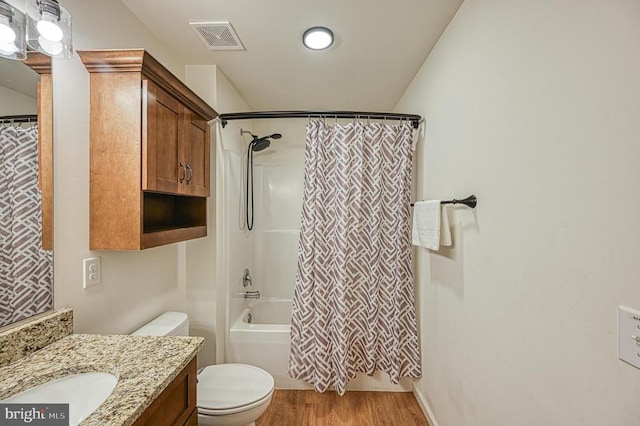 full bathroom featuring hardwood / wood-style floors, vanity, shower / tub combo, and toilet