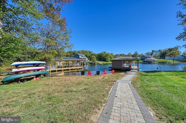 view of dock with a water view and a yard