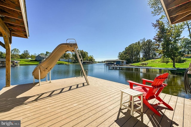 dock area with a lawn and a water view