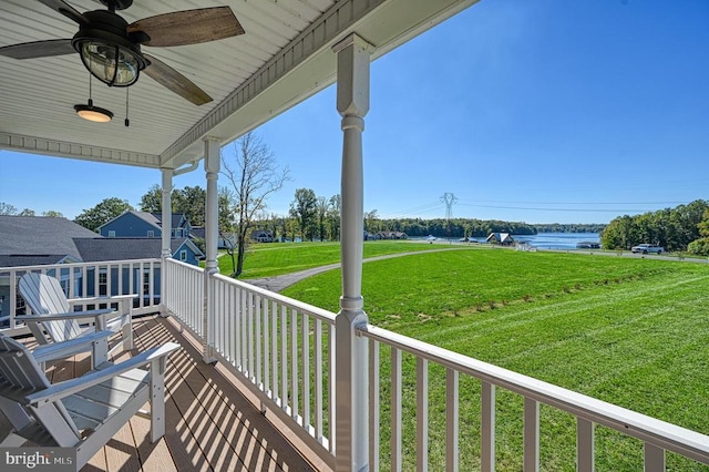 balcony featuring a water view and ceiling fan