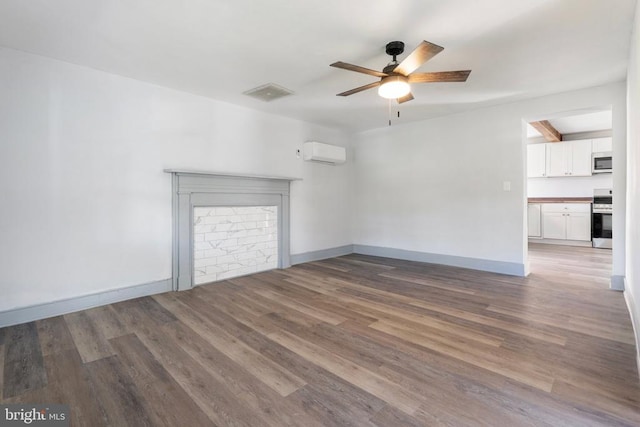 unfurnished living room with a wall mounted air conditioner, dark wood-type flooring, and ceiling fan