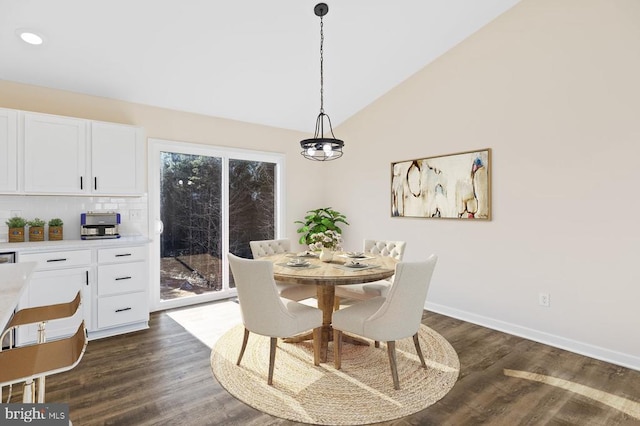 dining area featuring vaulted ceiling, a wealth of natural light, and dark hardwood / wood-style floors