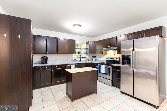 kitchen with appliances with stainless steel finishes, sink, a kitchen island, dark brown cabinets, and light tile patterned floors