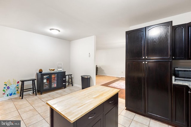 kitchen featuring butcher block countertops and light tile patterned floors