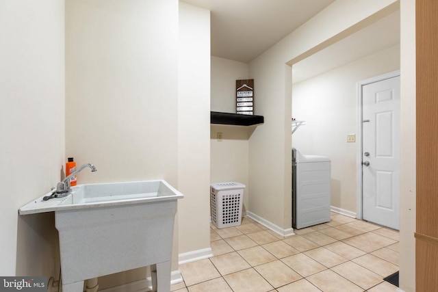 washroom featuring sink, washer / dryer, and light tile patterned floors