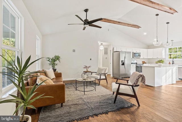 living room with beam ceiling, high vaulted ceiling, light wood-type flooring, and ceiling fan