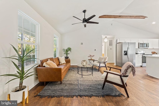 living room with beamed ceiling, light hardwood / wood-style flooring, high vaulted ceiling, and ceiling fan