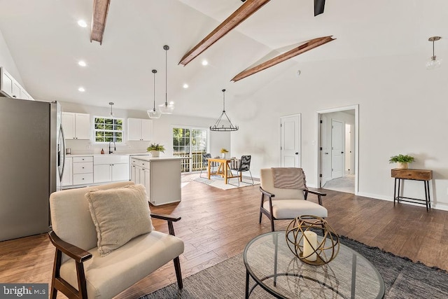 living room with sink, light wood-type flooring, beamed ceiling, high vaulted ceiling, and a chandelier