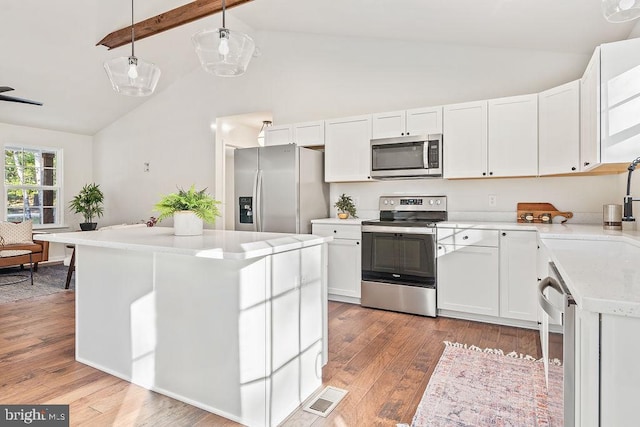 kitchen featuring appliances with stainless steel finishes, a center island, decorative light fixtures, white cabinets, and light hardwood / wood-style flooring