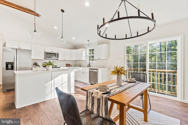 dining room featuring light hardwood / wood-style floors, an inviting chandelier, and high vaulted ceiling