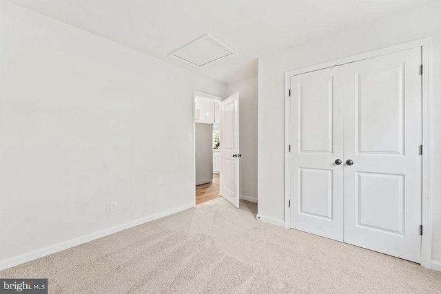 unfurnished bedroom with light colored carpet and a closet