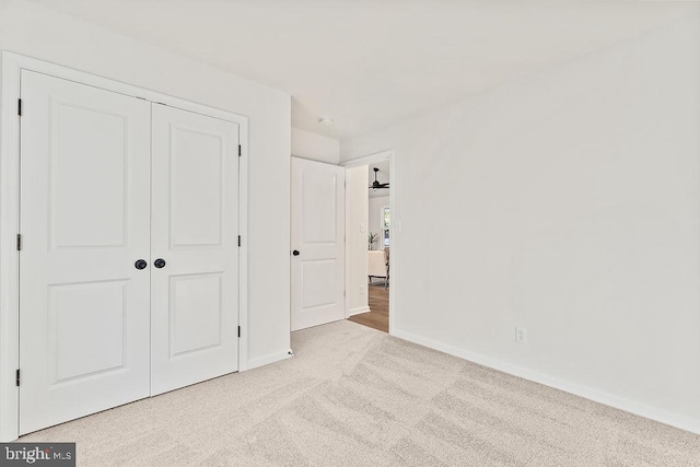 unfurnished bedroom with a closet and light carpet