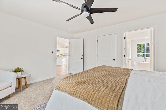 carpeted bedroom featuring ensuite bath and ceiling fan