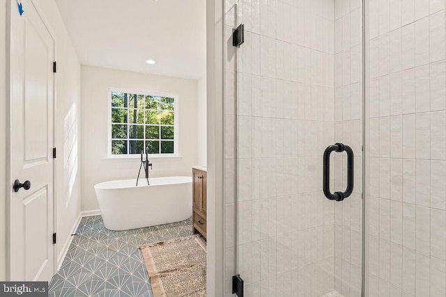 bathroom featuring vanity, shower with separate bathtub, and tile patterned floors