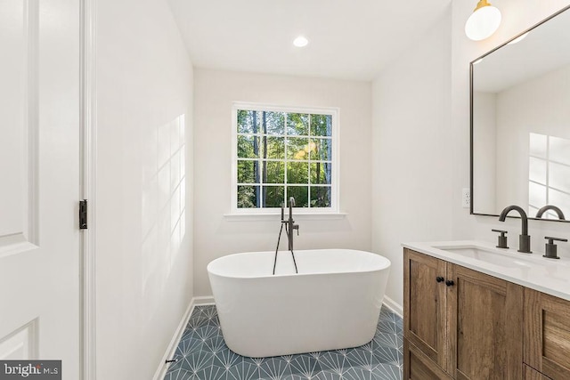 bathroom with vanity, tile patterned floors, and a bathtub