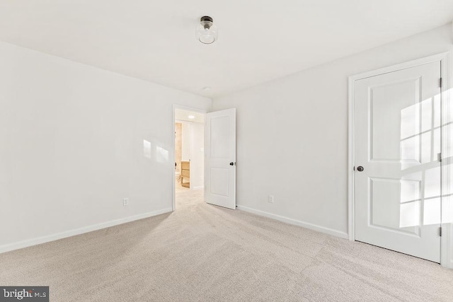 spare room featuring light colored carpet