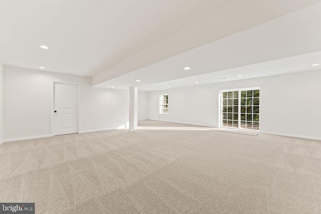 basement with a healthy amount of sunlight and light colored carpet