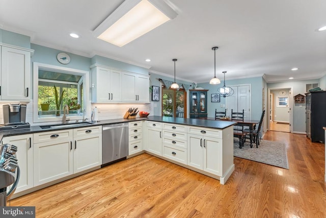 kitchen with kitchen peninsula, hanging light fixtures, appliances with stainless steel finishes, light wood-type flooring, and sink