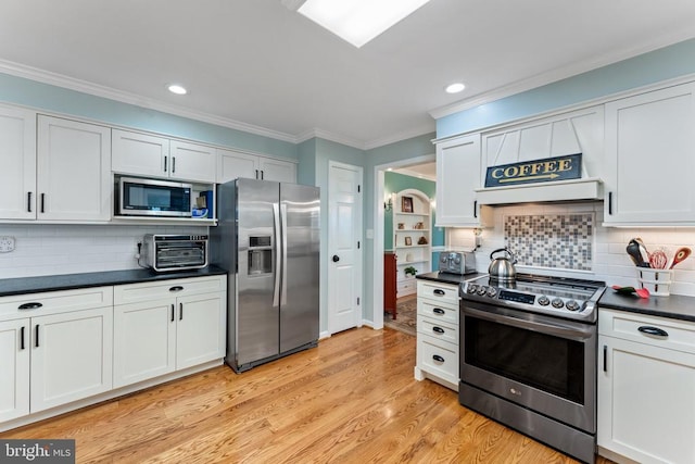 kitchen with white cabinetry, light hardwood / wood-style floors, appliances with stainless steel finishes, and backsplash