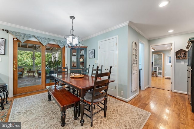 dining room with ornamental molding, a chandelier, and light wood-type flooring