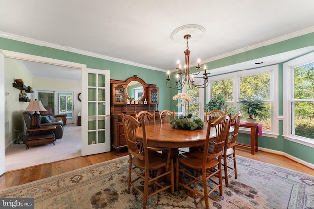 dining room with french doors, hardwood / wood-style flooring, plenty of natural light, and crown molding