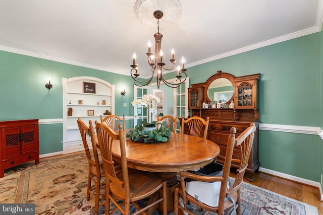 dining space with ornamental molding, hardwood / wood-style floors, and a notable chandelier