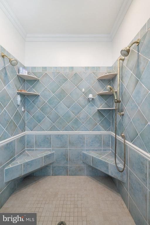 bathroom featuring ornamental molding and tiled shower