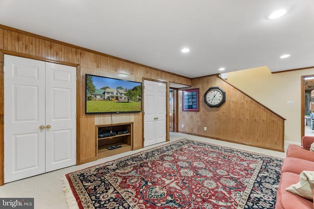 living room with ornamental molding and wooden walls