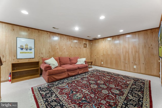 carpeted living room featuring crown molding and wooden walls