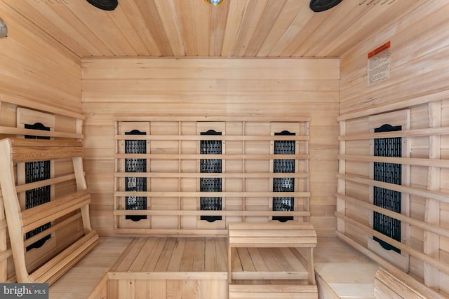 view of sauna / steam room with hardwood / wood-style flooring, wooden ceiling, and wooden walls