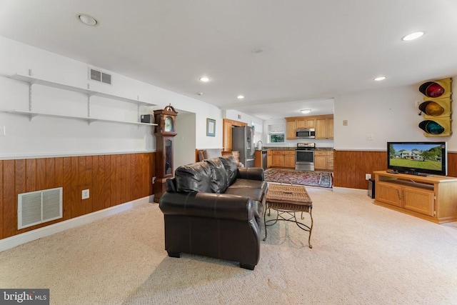 living room with light carpet and wood walls