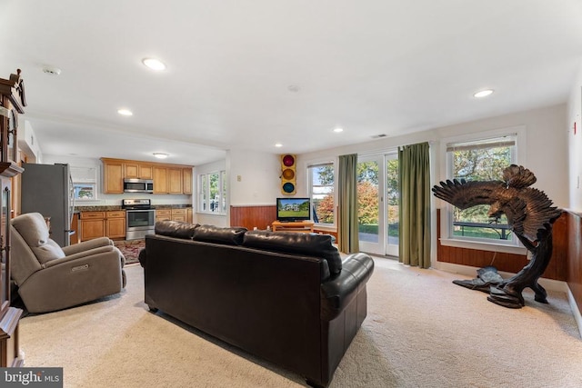 living room with light colored carpet and wood walls