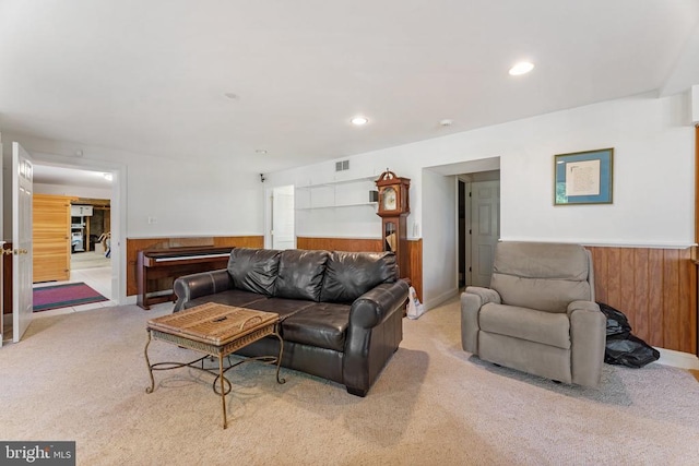 living room with wooden walls and light colored carpet