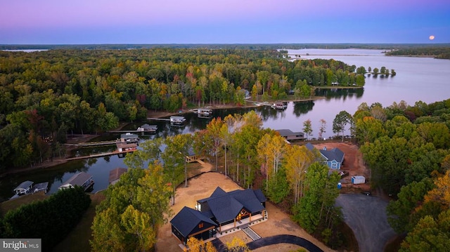 aerial view at dusk featuring a water view