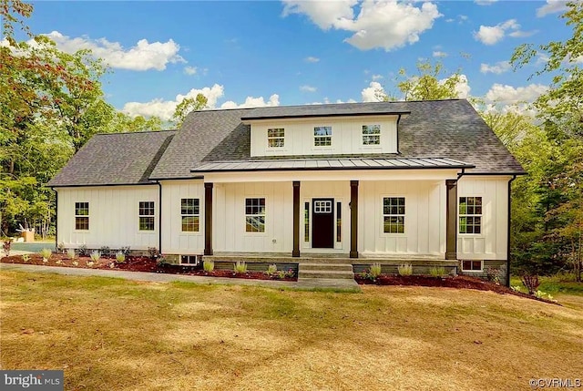 modern inspired farmhouse featuring covered porch and a front lawn