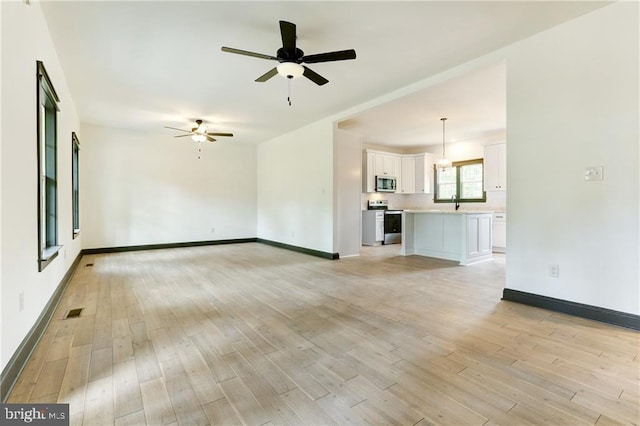 unfurnished living room with light hardwood / wood-style flooring and ceiling fan