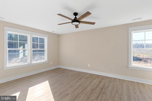 empty room with light hardwood / wood-style floors and ceiling fan