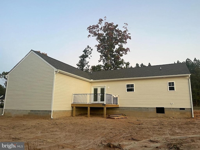 rear view of property featuring a wooden deck and french doors