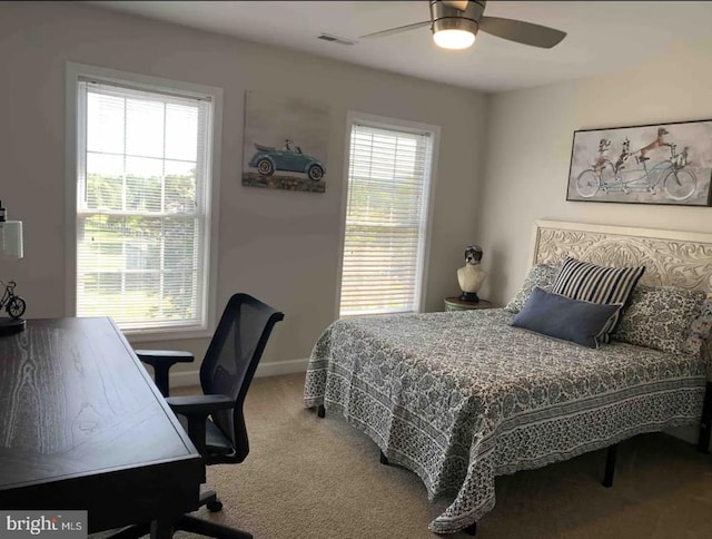 bedroom with ceiling fan, multiple windows, and carpet floors