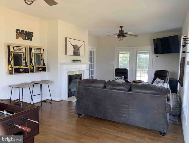 living room with ceiling fan and dark hardwood / wood-style flooring