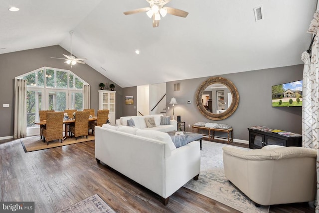 living room with dark wood-type flooring, vaulted ceiling, and ceiling fan