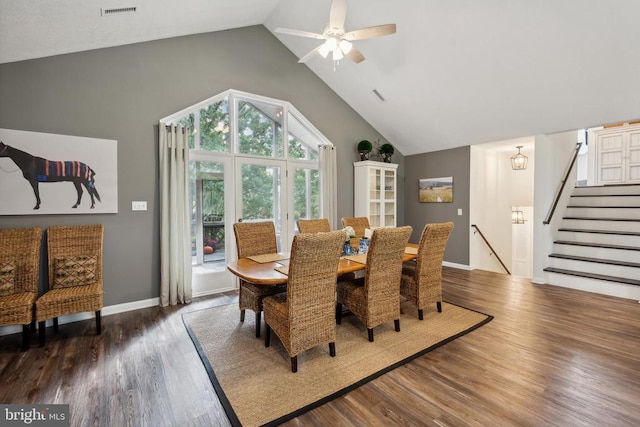 dining space with ceiling fan, high vaulted ceiling, and dark hardwood / wood-style flooring