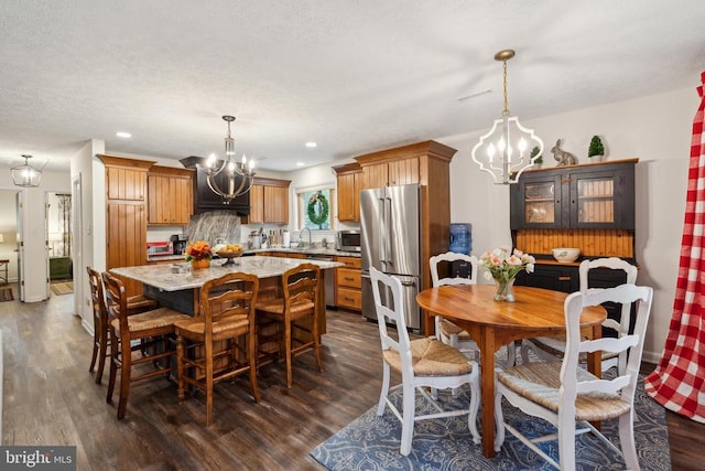 dining space with sink, a notable chandelier, and dark hardwood / wood-style floors