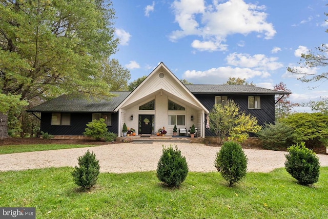 view of front of house featuring covered porch and a front lawn