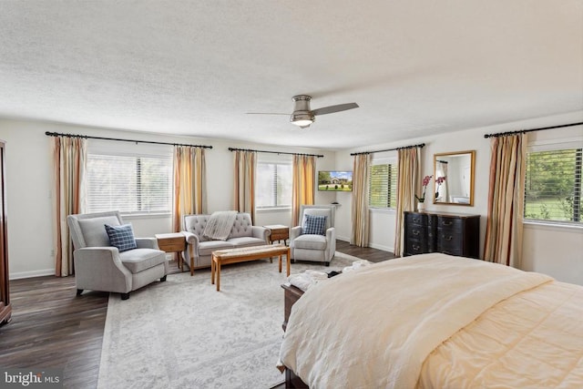 bedroom with ceiling fan, a textured ceiling, and dark hardwood / wood-style floors